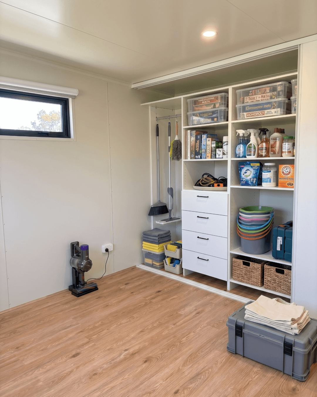 Utility and storage room with built-in shelving and vinyl plank flooring